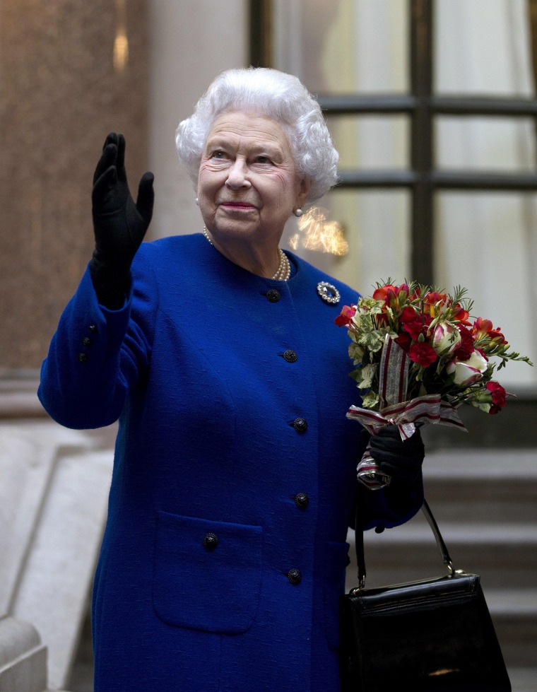 Image: Britain's Queen Elizabeth waves to workers at the end of her tour of the Foreign and Commonwealth Office to mark her Diamond Jubilee
